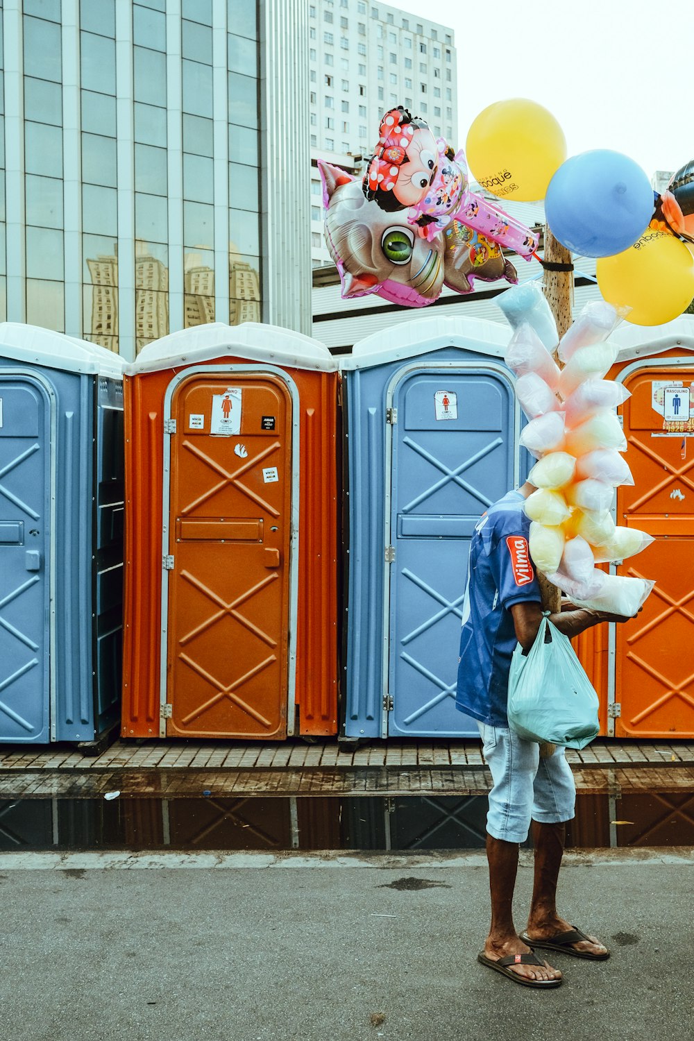 a person standing in front of a row of portable toilets