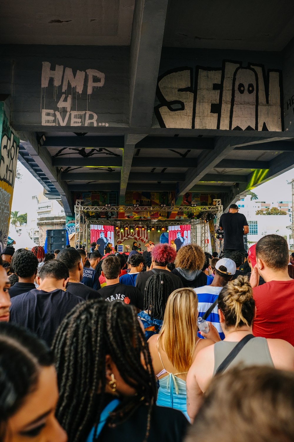 a crowd of people standing under a bridge