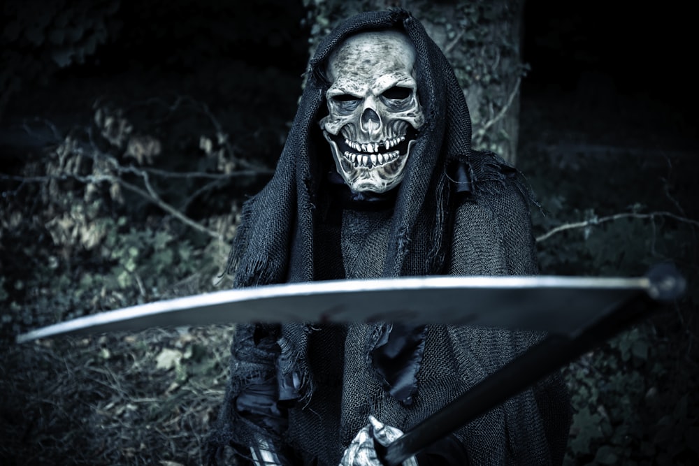 a skeleton dressed in black holding a sword