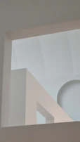 An abstract view of non-linear architectural forms casting delicate shadows.