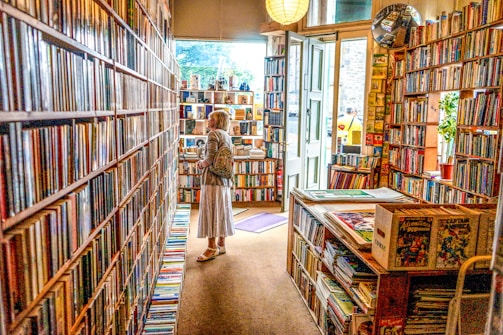 A cozy comic store corner bathed in soft sky blue light with shelves full of colorful graphic novels.