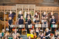 A small group of musicians tuning their instruments before starting a private event performance.