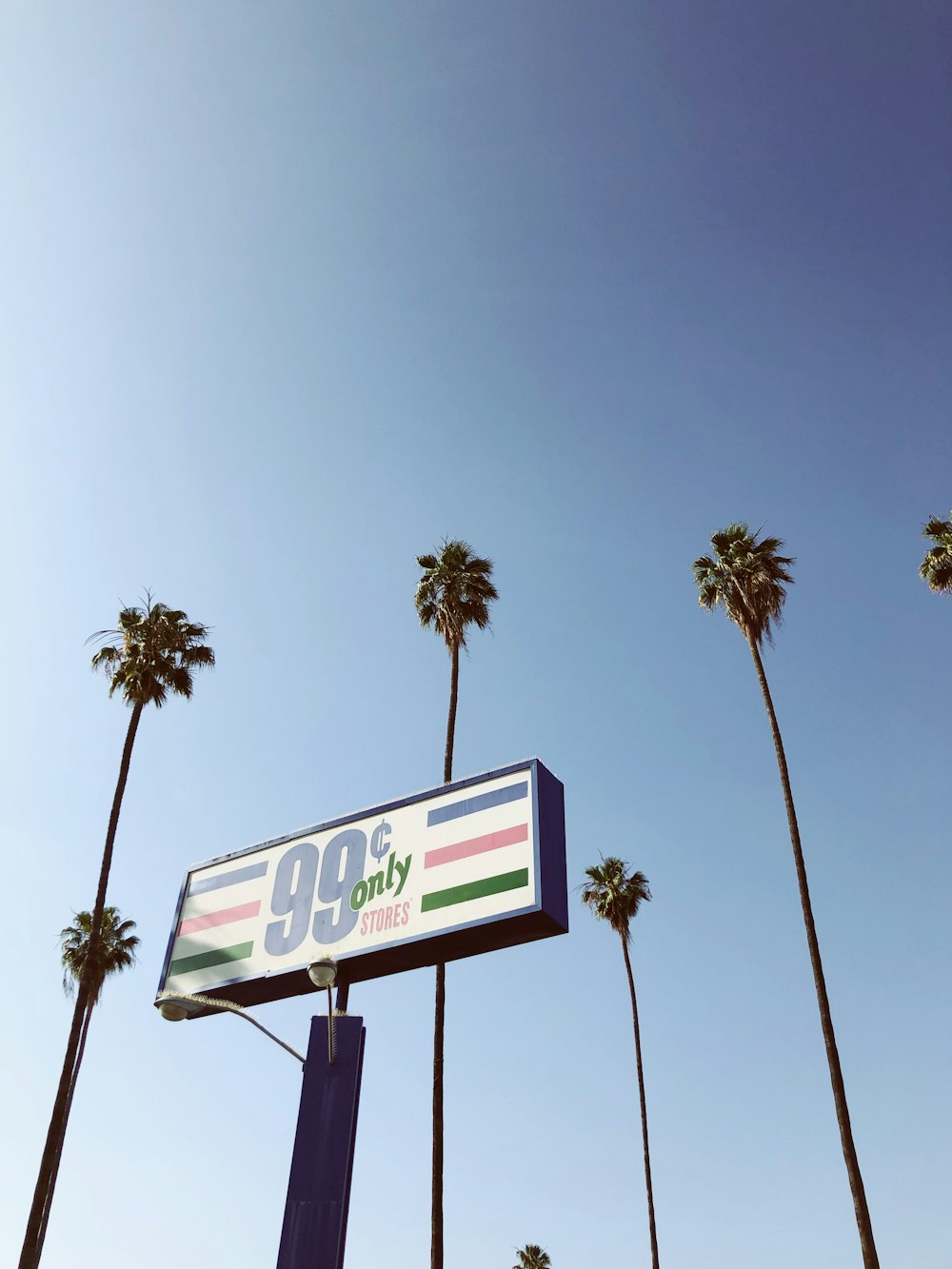 a gas station sign with palm trees in the background