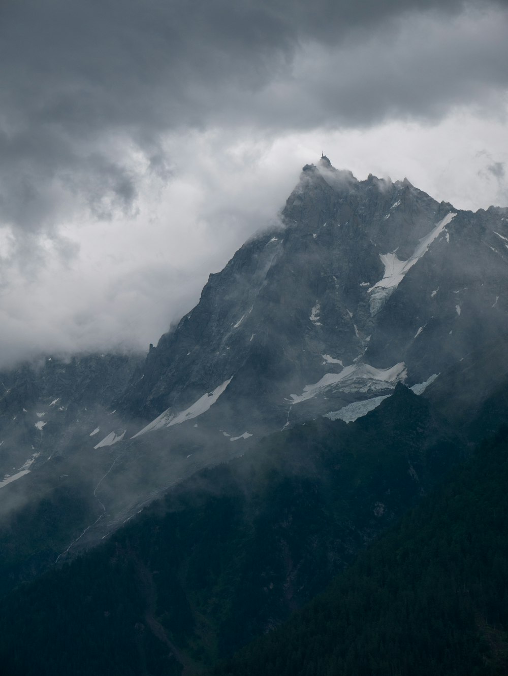 Una grande montagna coperta di neve sotto un cielo nuvoloso