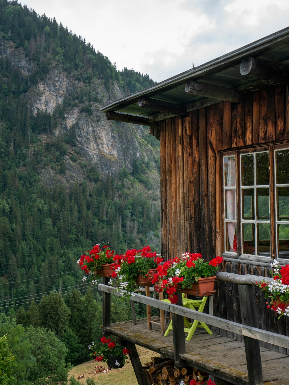 a wooden cabin with flowers on the porch