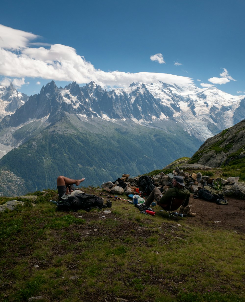 a man sitting on top of a lush green hillside