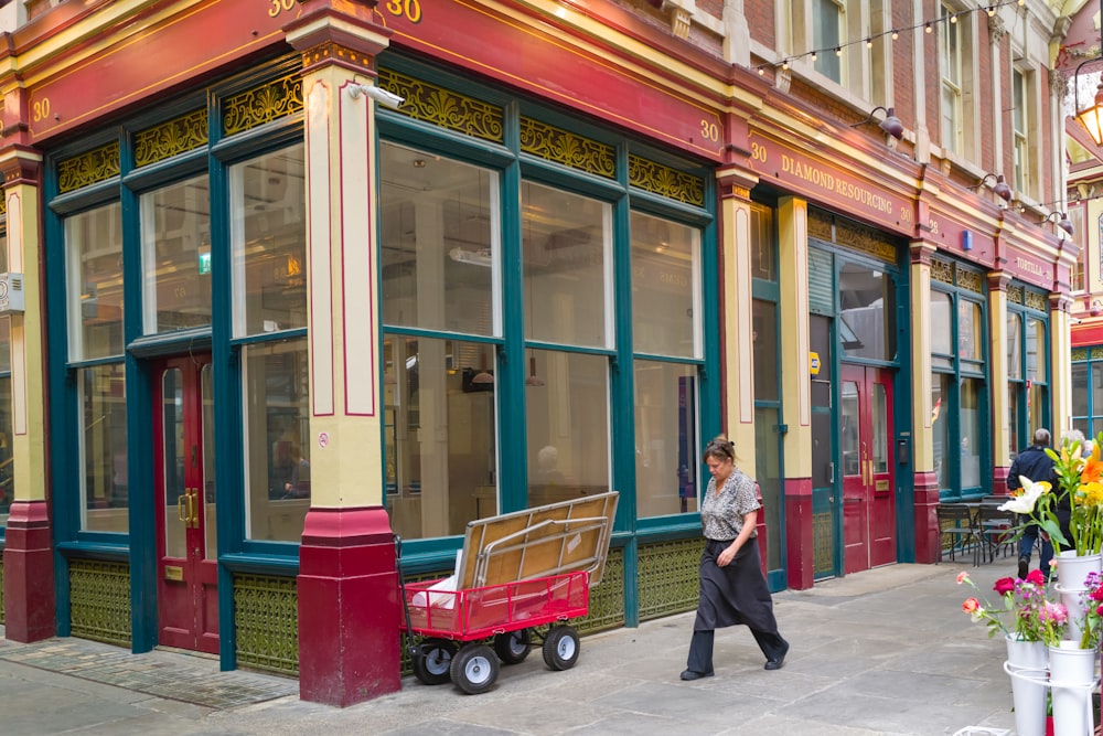 a woman walking down a street past a building