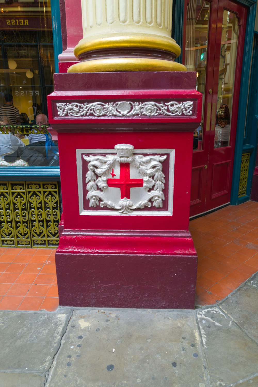 a red and white pillar with a red cross on it