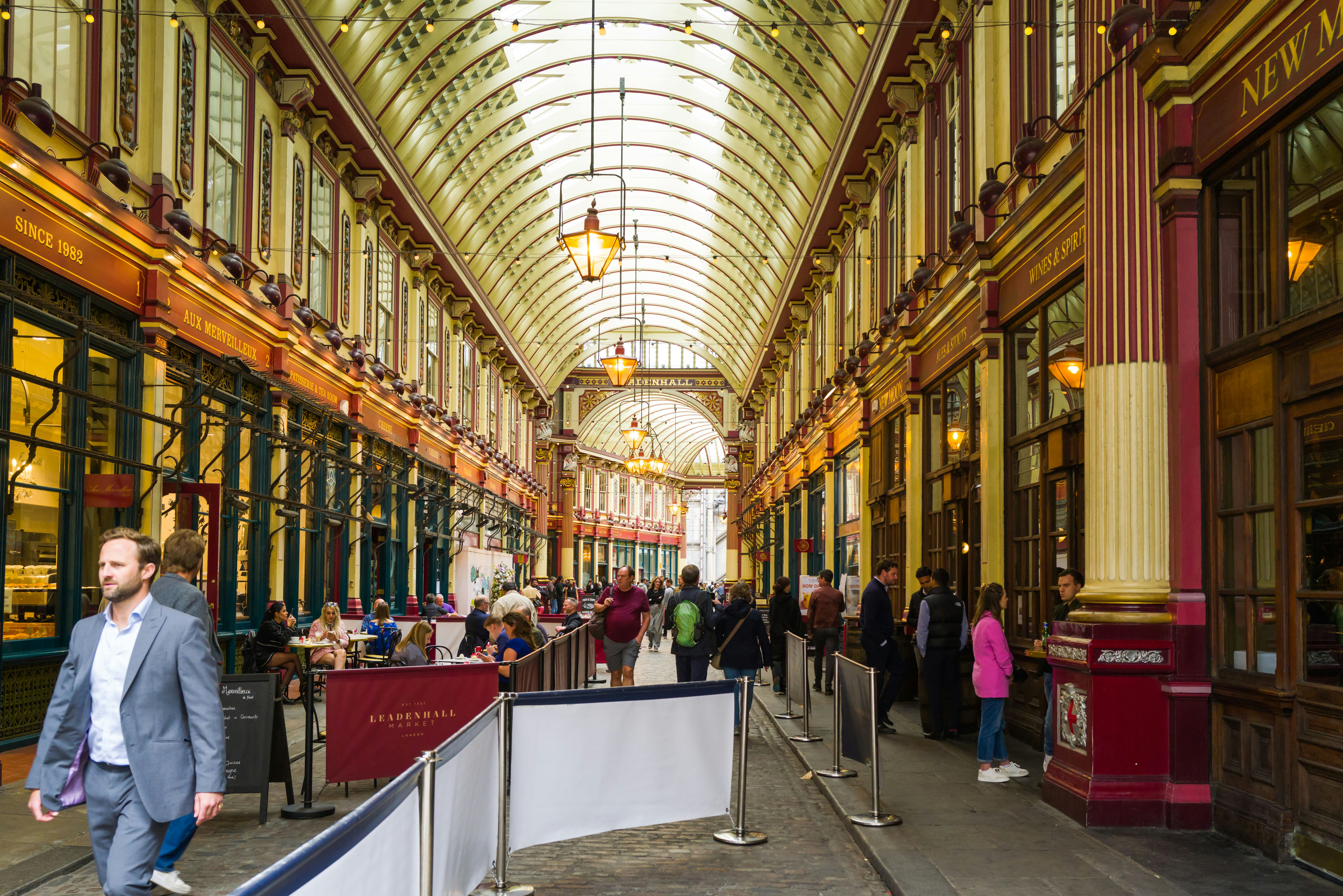 a group of people walking down a long hallway, Leadenhall Market