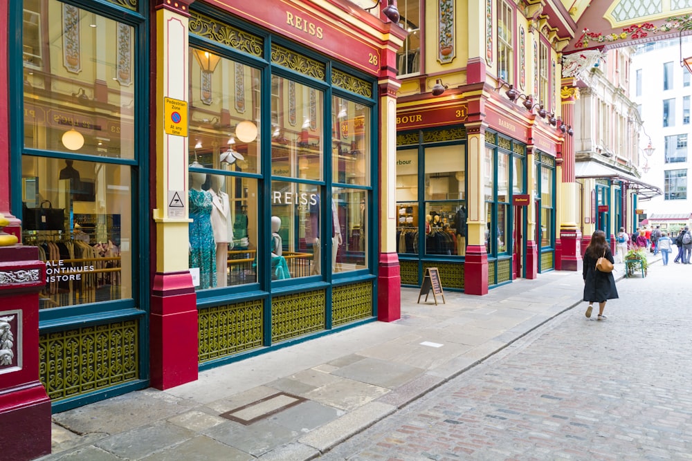 a woman is walking down the street in front of a store