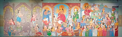 A vibrant mural with three main sections depicting various scenes, including religious and cultural rituals. Central focus on a deity surrounded by worshippers, musicians, and people in traditional attire engaging in celebrations. The left section has muted colors with intricate patterns and figures, while the middle and right sections are more colorful with detailed depictions of festivities and community gatherings.