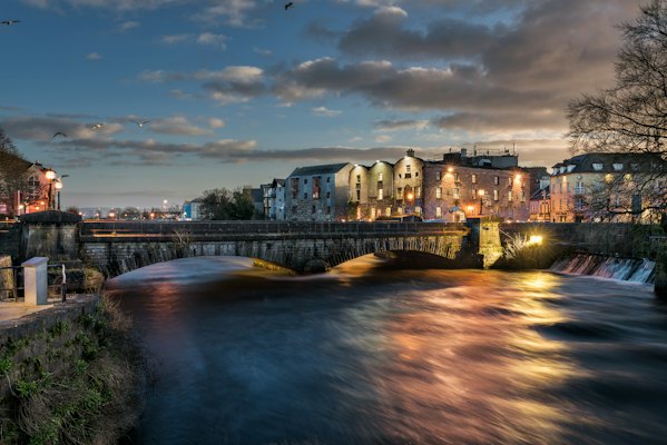 A river running through a city at night — Galway, Ireland
