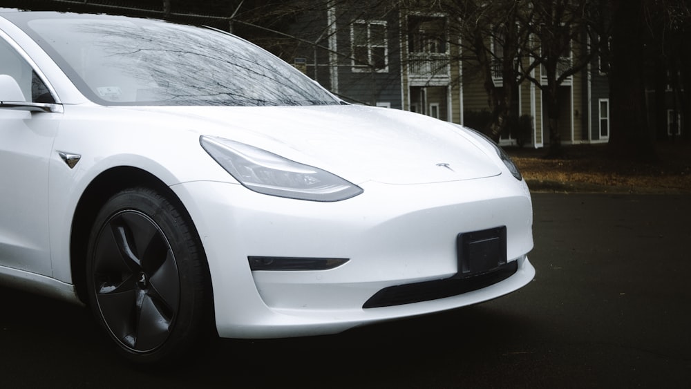 a white electric car parked in a parking lot