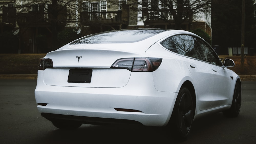 a white tesla parked in a parking lot