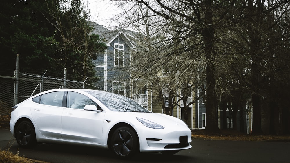 a white car parked in front of a house