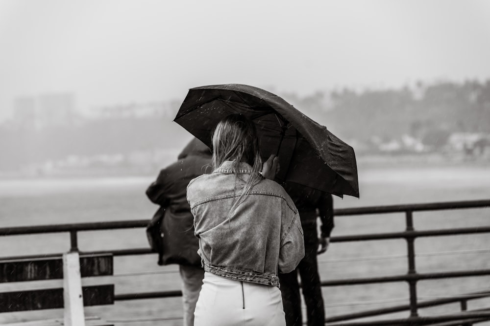 a black and white photo of a woman holding an umbrella