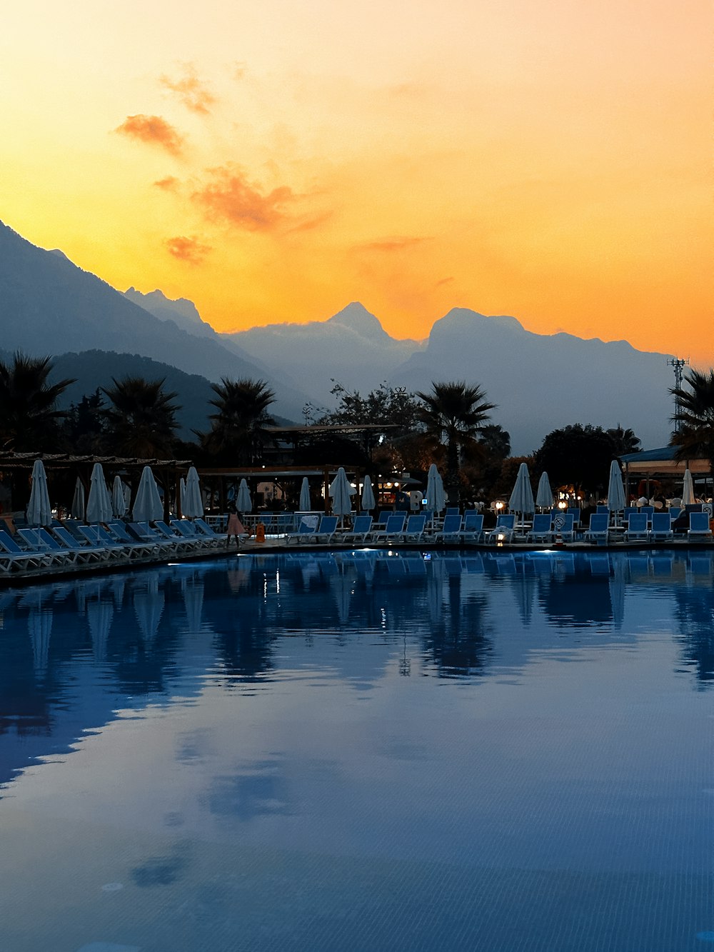 a large swimming pool with chairs and umbrellas