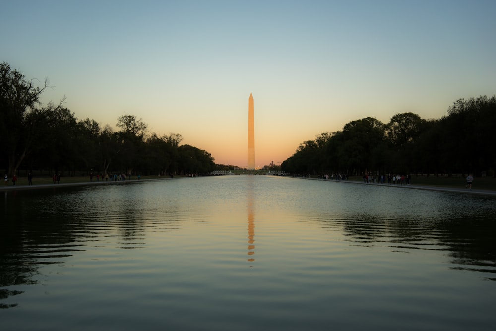 the washington monument reflecting in the water at sunset