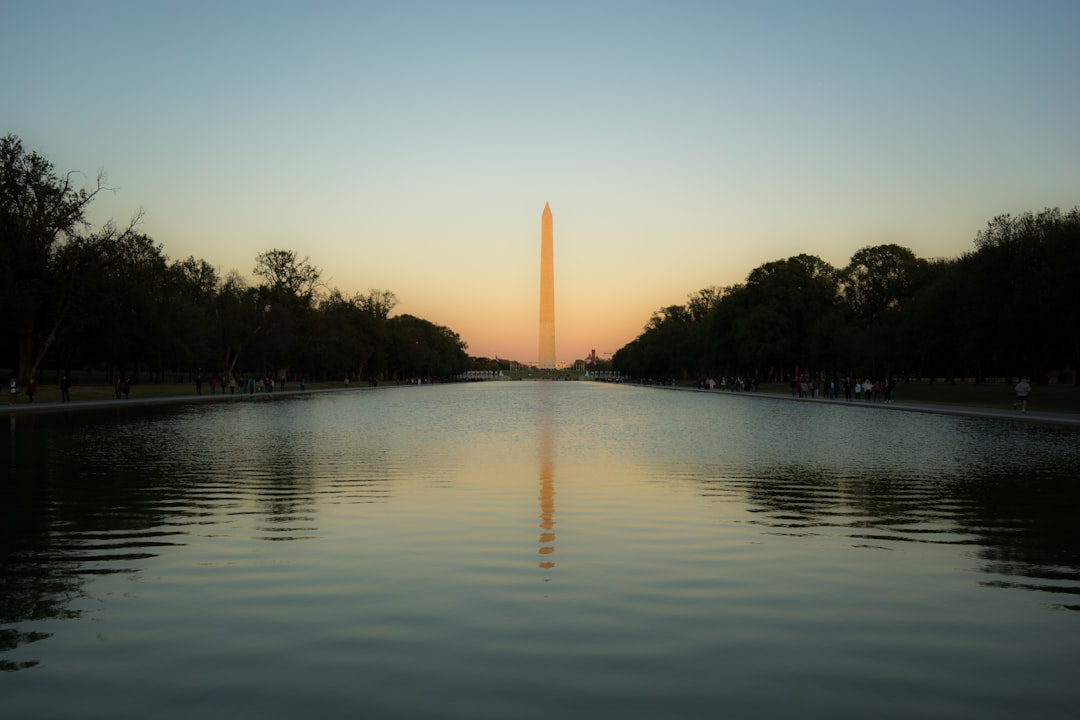 the washington monument reflecting in the water at sunset, The Washington Monument in Washington DC, reflected in the reflecting pool on the National Mall, during sunset.