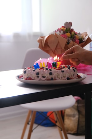 A beautifully decorated birthday cake with candles and balloons.