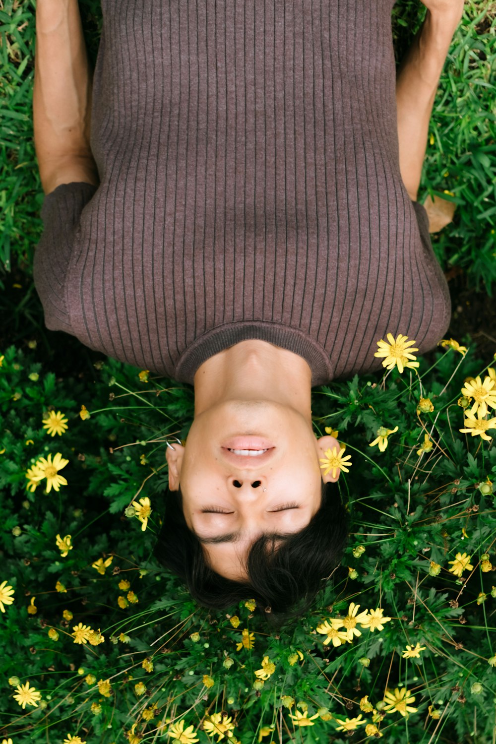 a person laying down in a field of flowers