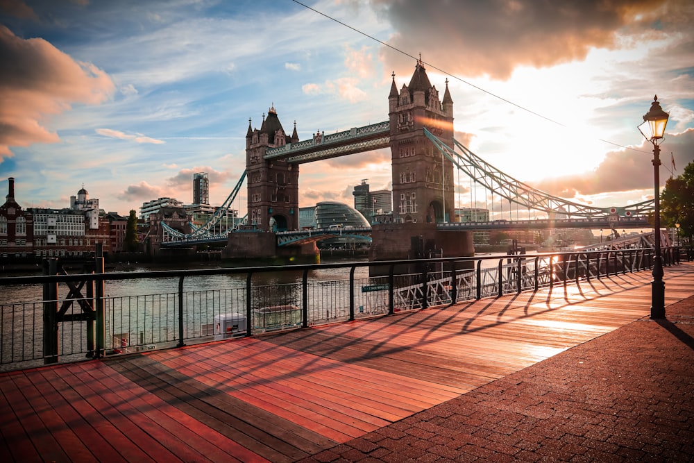 the sun is setting behind the tower bridge