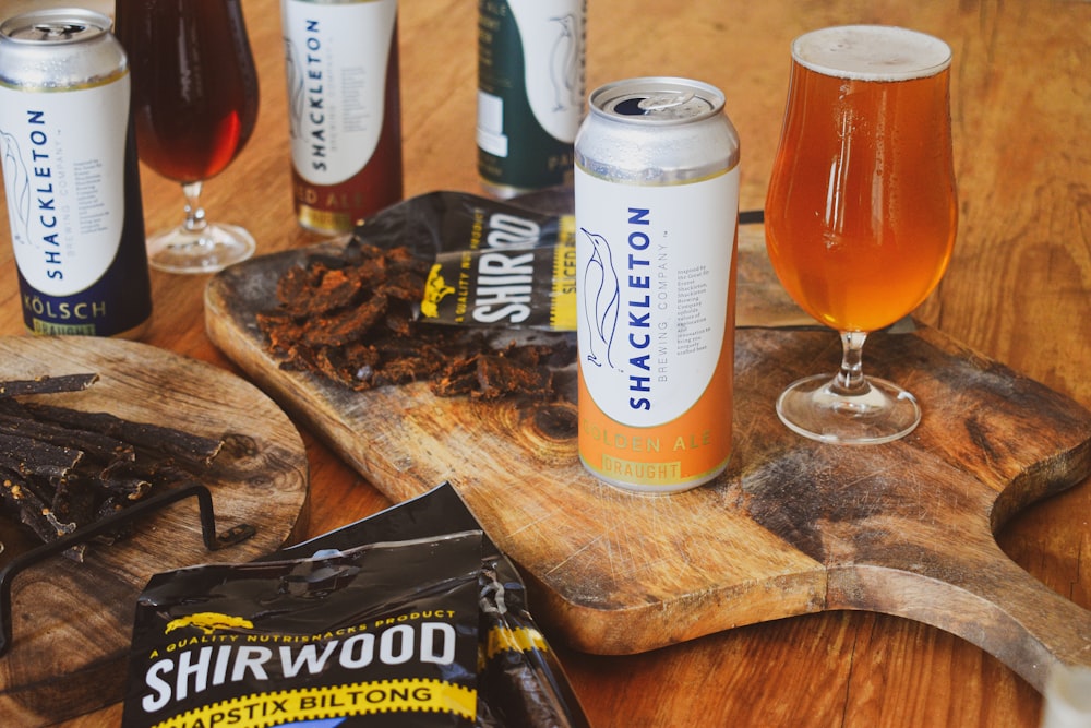 a wooden table topped with assorted drinks and snacks