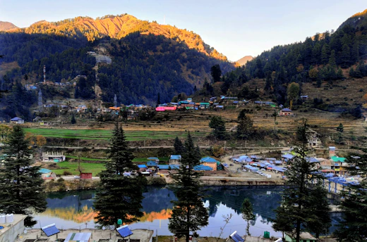 A serene sunrise over a quiet mountain village, inviting travelers to pause and reflect.