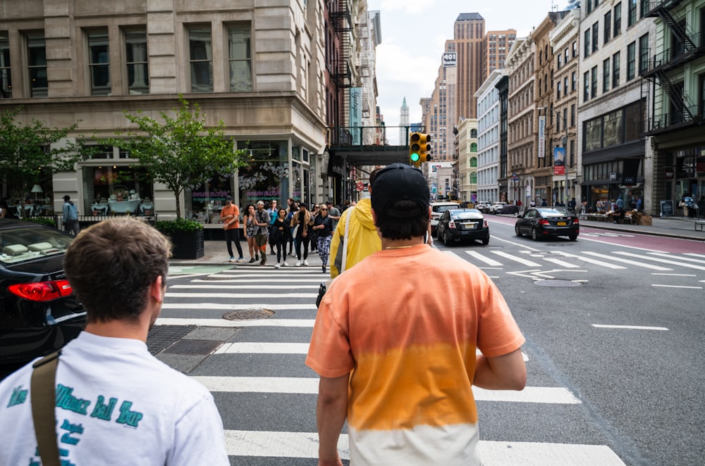 a group of people walking across a cross walk