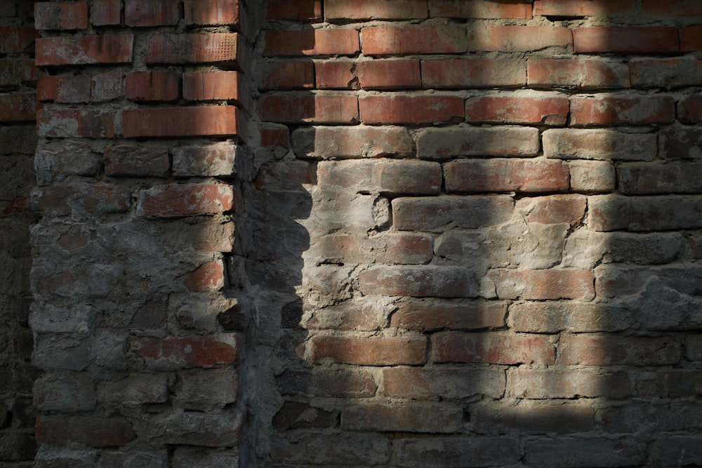 the shadow of a person standing in front of a brick wall