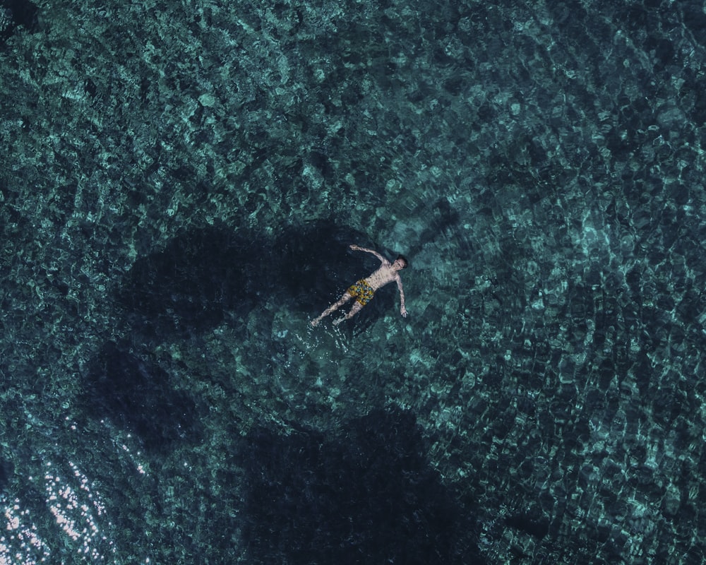 a person floating in the ocean on a surfboard