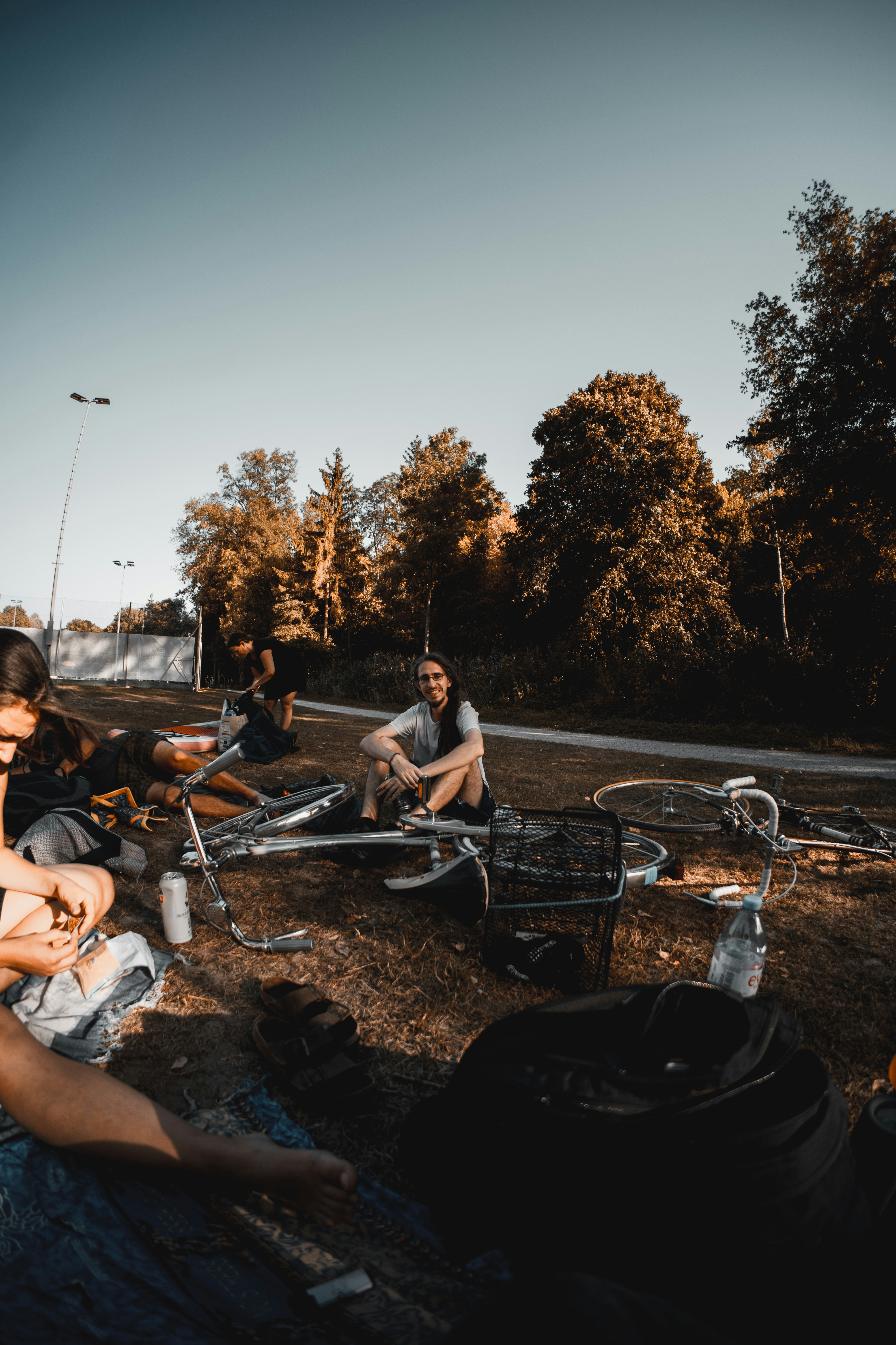 a group of people sitting on a field next to a bike