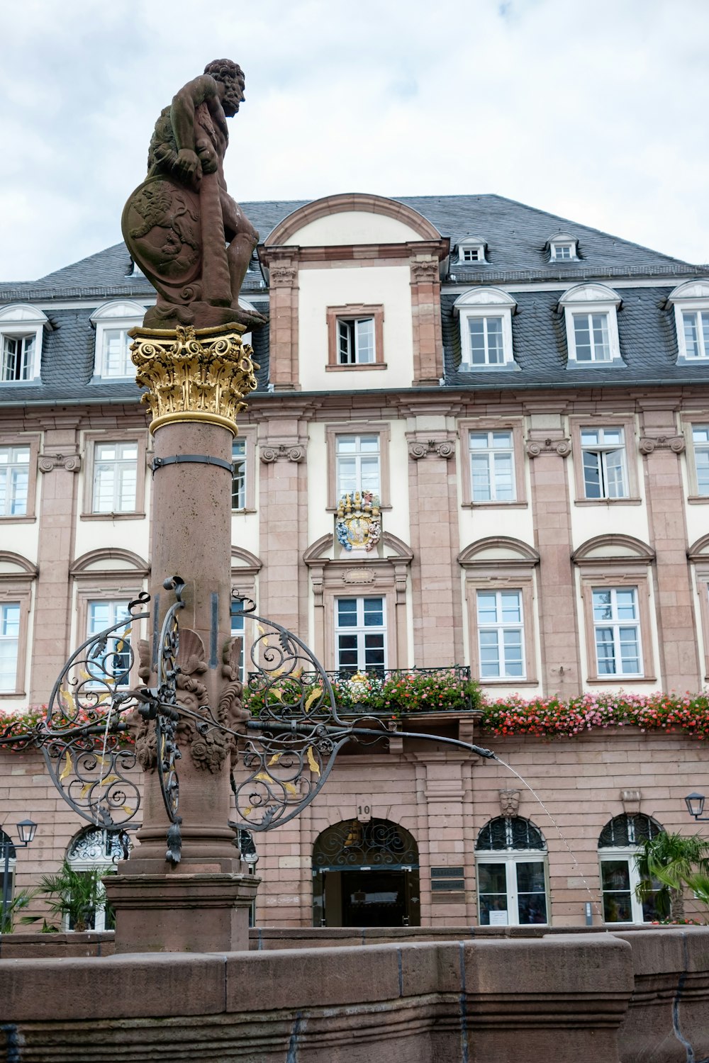 une statue d’un homme assis au sommet d’un lampadaire