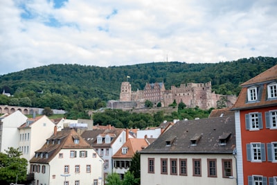 A scenic European castle surrounded by lush greenery and clear blue skies.