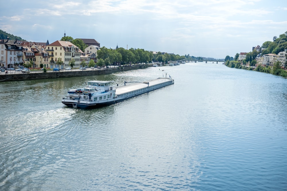 a boat traveling down a river next to a city