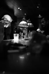 A quiet bar interior with a single glass catching the soft glow of the evening.