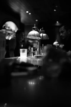 A quiet bar interior with a single glass catching the soft glow of the evening.