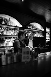 Two bar owners discussing supplier options over coffee