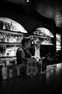 Two bar owners discussing supplier options over coffee