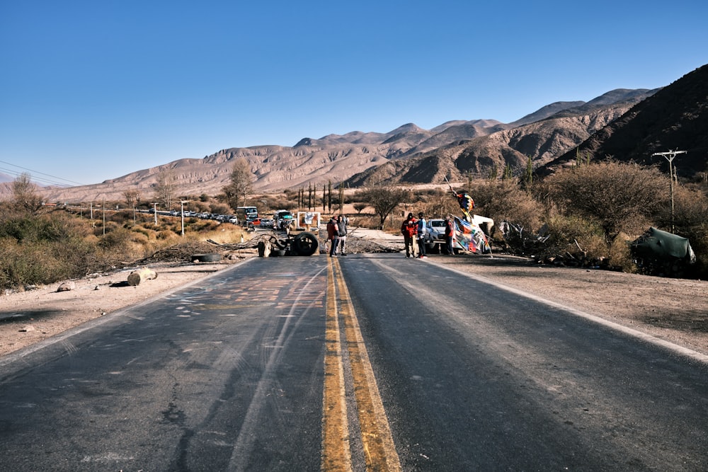 a couple of people standing on the side of a road