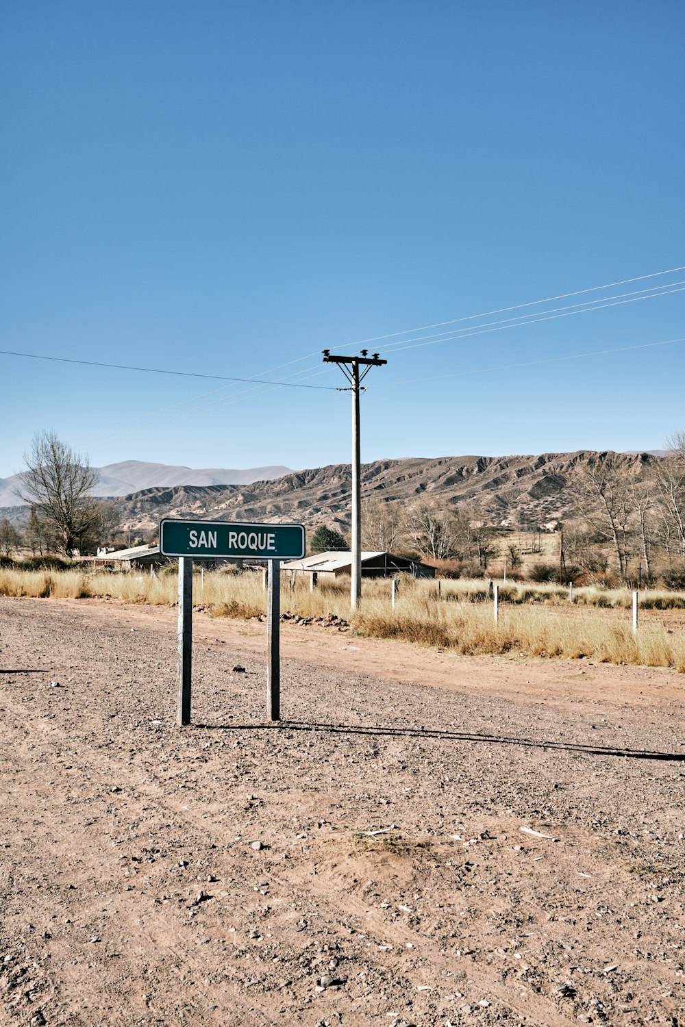 a street sign on the side of a dirt road