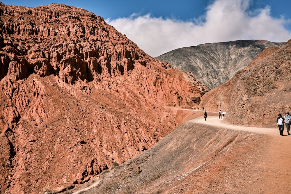 a group of people walking down a dirt road