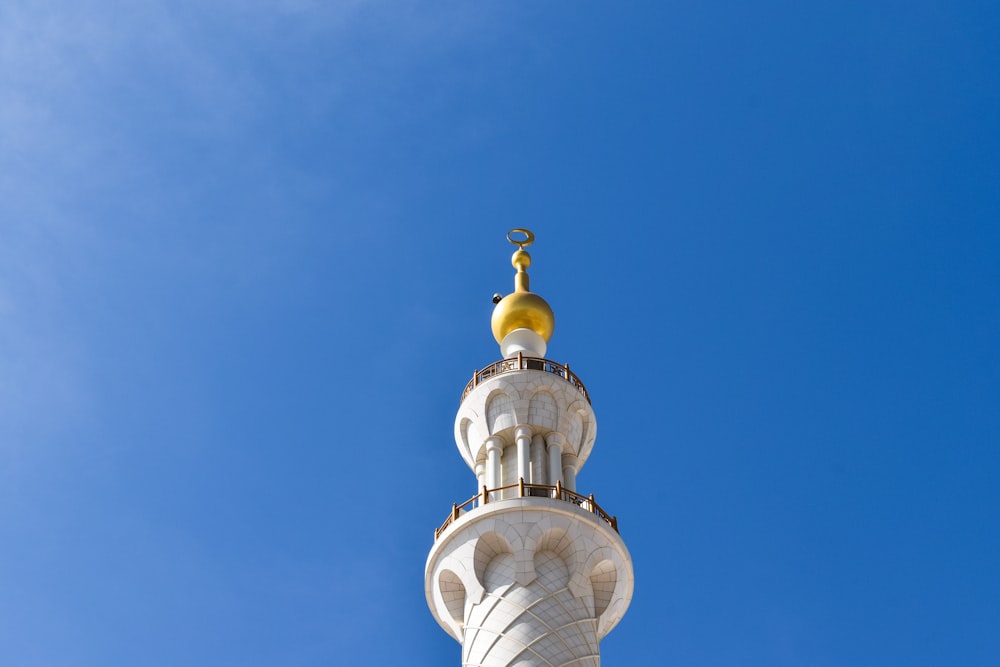 a tall white tower with a gold dome on top