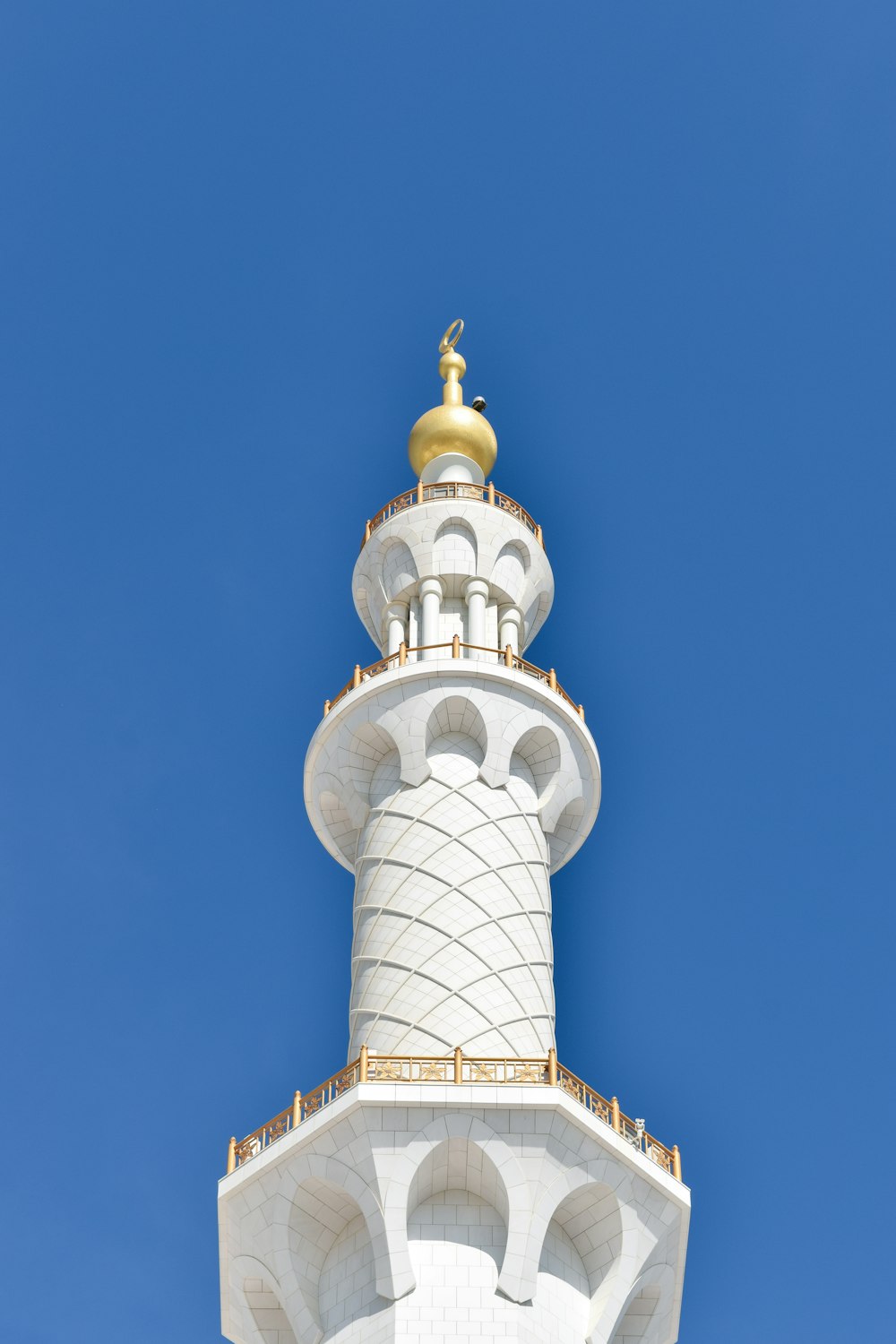 a tall white tower with a gold top