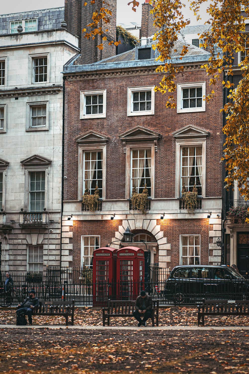 a red phone booth sitting in front of a tall building
