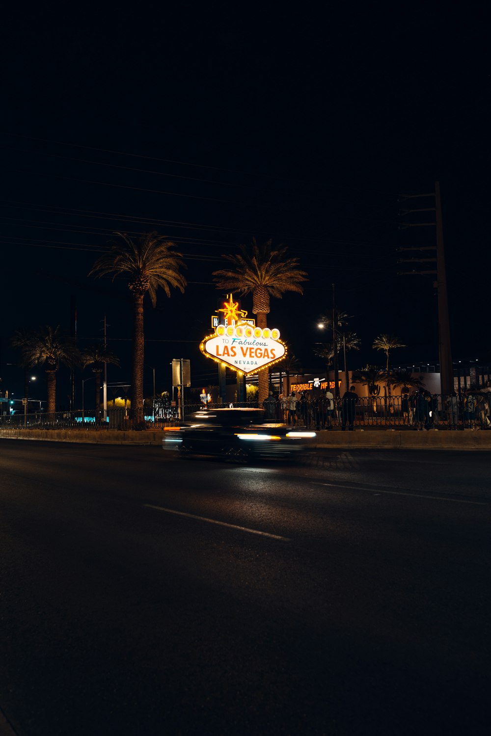 a car driving down a street at night