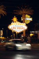 Guests posing excitedly in front of the iconic 'Welcome to Fabulous Las Vegas' sign at sunset