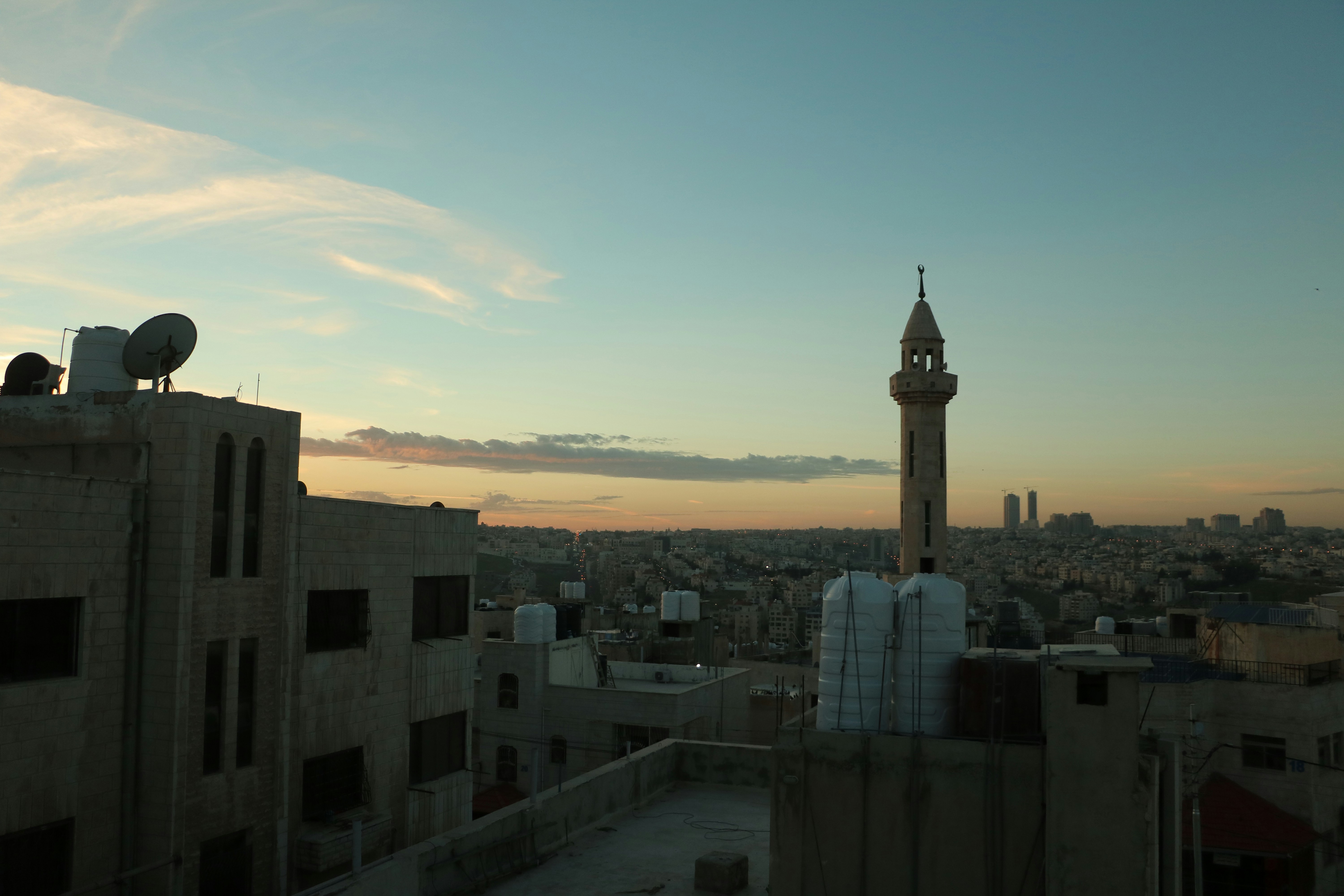 Casablanca at dusk — Hassan II Mosque minaret silhouette against purple and orange sky, Atlantic Ocean in background