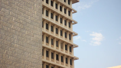 A multi-story RCC building rising against a clear sky, showcasing solid construction.