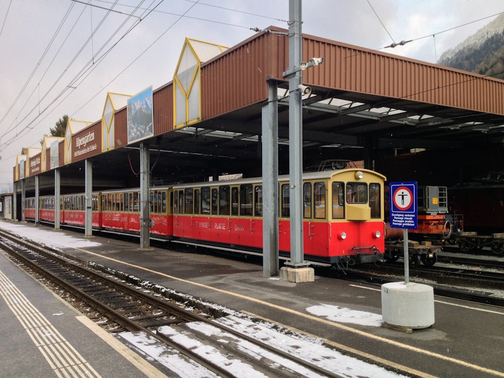 Ein rot-gelber Zug, der in einen Bahnhof einfährt